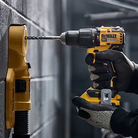 Person using a Dewalt drill on a brick wall
